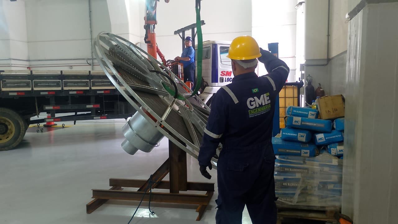 Enrolador de cabos do pórtico principal sendo movimentado por ponte rolante amarela dentro de galpão