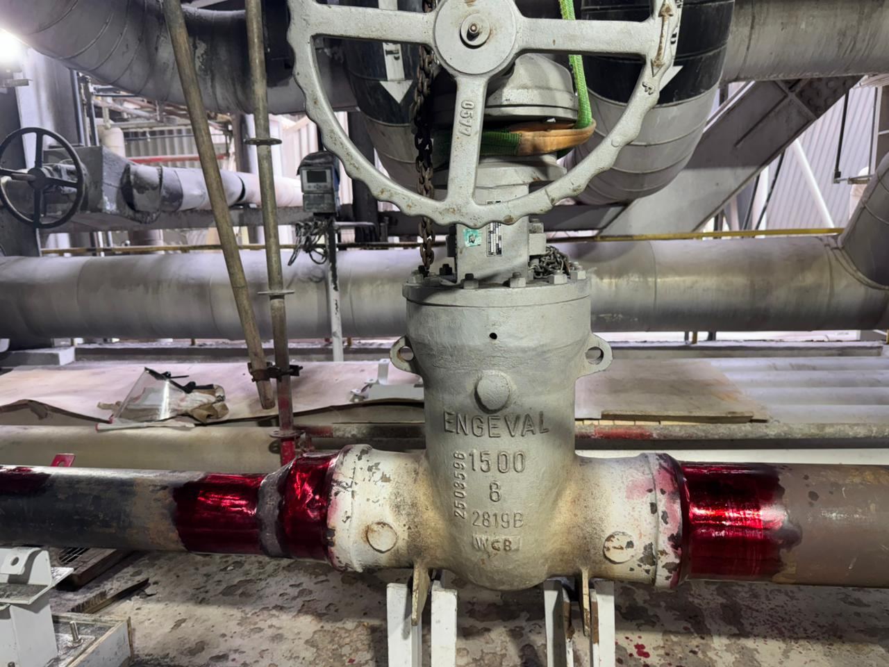 Válvula industrial ENGEVAL instalada em tubulação com marcações vermelhas de identificação de solda