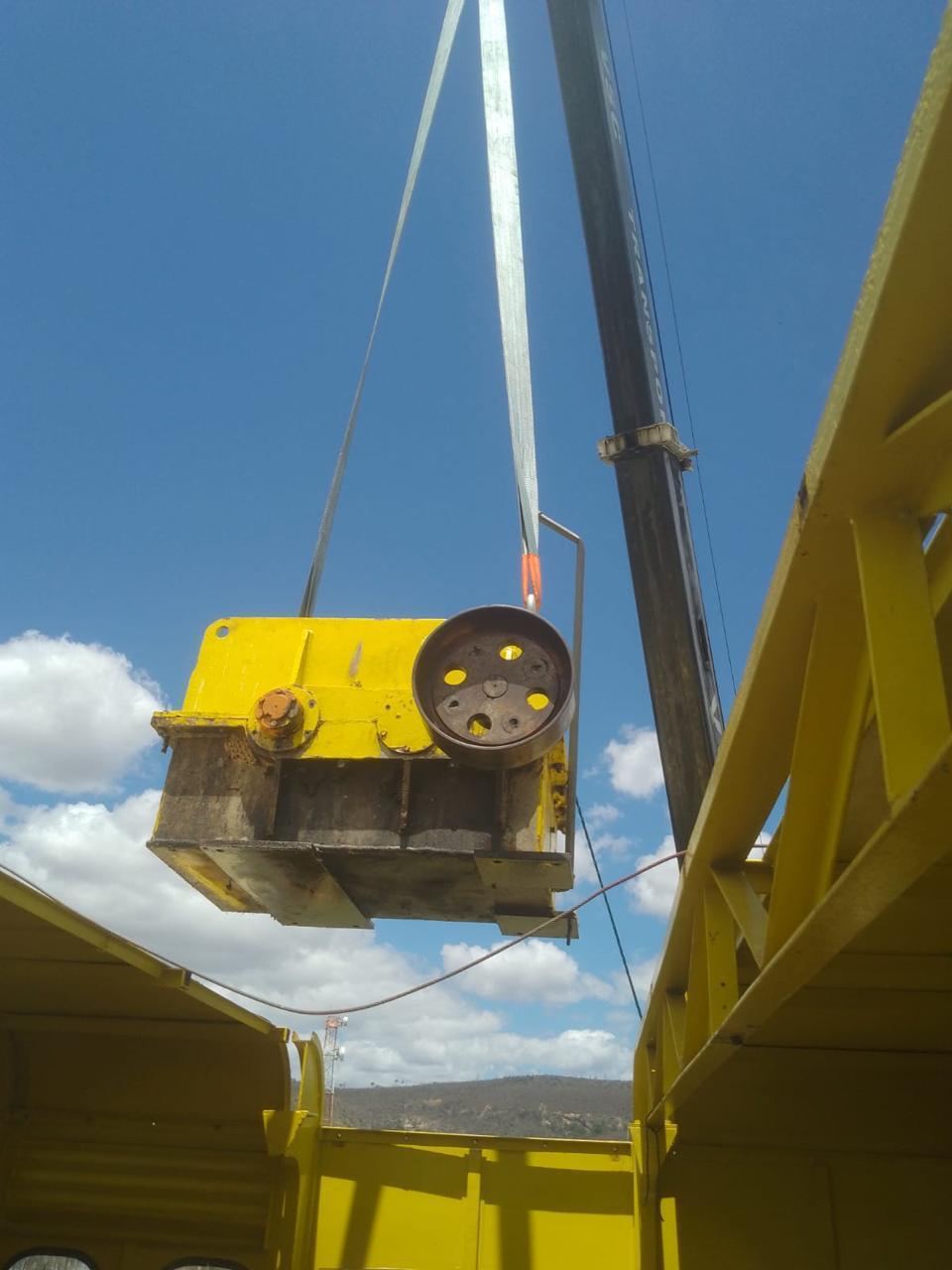 Redutor amarelo suspenso por talha contra o céu azul